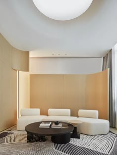 a living room filled with white furniture and a round table in front of a window