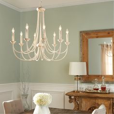 a chandelier hanging from the ceiling in a room with green walls and white trim