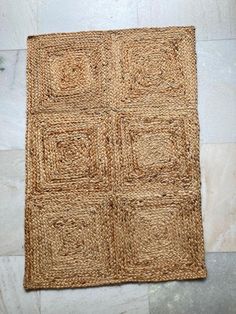 a close up of a rug on the floor with white tiles in the back ground