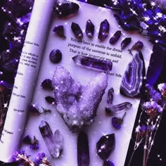 an open book with purple crystals on it