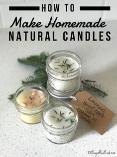 three small candles sitting on top of a counter next to pine cones and evergreen branches