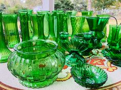 many green glass vases and bowls on a table