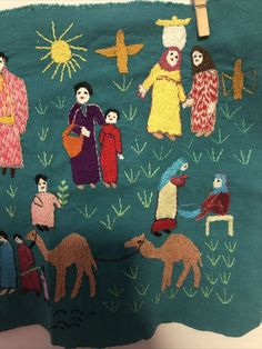 an embroidered cloth with people and animals on it