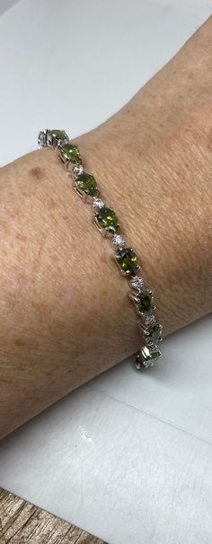 Vintage Peridot and Cubic Zirconia Rhodium Finished 925 Sterling Silver Tennis Bracelet The stones are deep colors and well matched.  The sterling silver is plated with rhodium to protect the bracelet from tarnish and give the appearance of white gold. 7.5 inches Our jeweler can shorten it for a $20 fee.  All jewelry is shipped free in the US in a nice gift box.   Check out our over a THOUSAND great reviews Engraving is $4 per letter and is not always perfect depending on the piece. It can take Wedding Bracelets, Silver Tennis Bracelet, Peridot Bracelet, Peridot Jewelry, Cz Bracelet, Jade Bracelet, August Birth Stone, Deep Colors, Wedding Bracelet