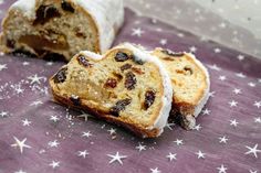 two pieces of bread with raisins and icing on a purple table cloth