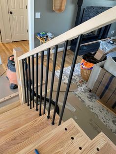 a wooden stair case with black handrails in a living room