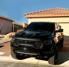 a black truck parked in front of a house