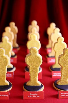 rows of cookies shaped like people on red table cloth