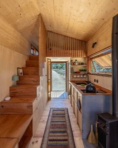 the interior of a tiny house with stairs leading up to the kitchen and living room