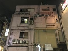 an apartment building with air conditioners on the outside and windows in the top floor