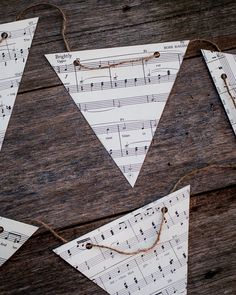 paper buntings with musical notes on them sitting on a wooden table next to string