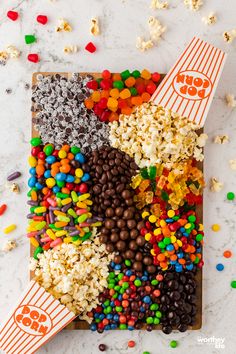 the popcorn tray is filled with different kinds of candy