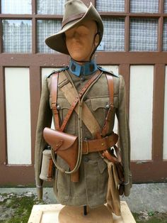 a soldier's uniform and hat on display in front of a building