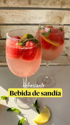 two glasses filled with watermelon and lemonade on top of a white table