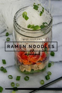 a glass jar filled with noodles and vegetables