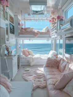 a room with bunk beds, couches and pillows on the floor next to the ocean