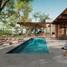 an outdoor swimming pool with lounge chairs and tables next to it, surrounded by trees