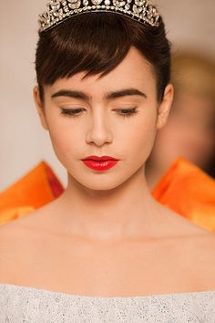 a woman wearing a tiara and red lipstick