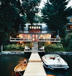 a boat is docked at the end of a dock with a house in the background