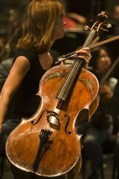 a woman playing the cello in front of an audience