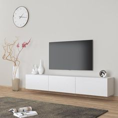 a large flat screen tv sitting on top of a white entertainment center