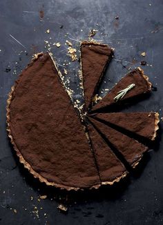 a piece of chocolate pie on top of a black surface with one slice cut out