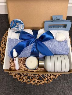 an open box with some items in it and a blue ribbon around the bow on top