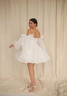 a woman in a white dress posing for the camera