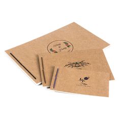 three brown envelopes with stickers and writing on them, one has a pen in it