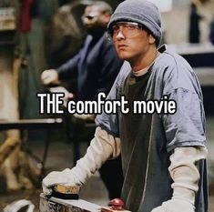 a man holding a skateboard with the words the comfort movie in front of him