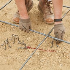 a pair of feet wearing work gloves standing on top of a construction site with tools