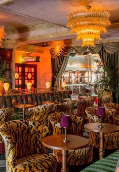 the interior of a fancy restaurant with tiger print furniture and chandeliers hanging from the ceiling