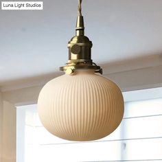 a light fixture hanging from the ceiling in a room with white walls and flooring