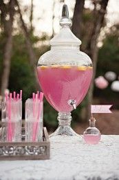 a table topped with lots of pink drinks