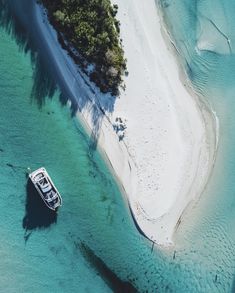 an aerial view of a boat in the water next to a sandy beach and shore