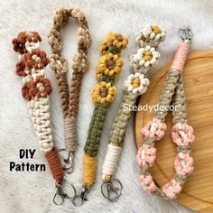 four crocheted keychains with flowers on them sitting next to a cutting board