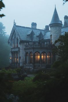 an old castle like building lit up in the dark with lights shining on it's windows