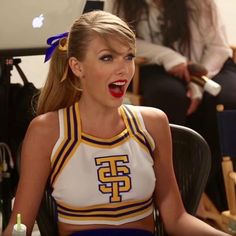 a cheerleader is sitting in front of an apple computer