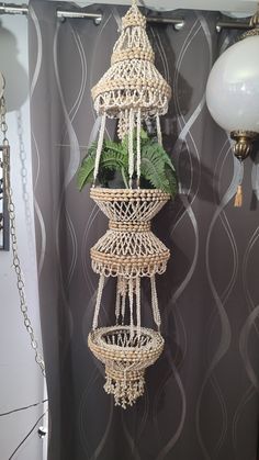 a hanging planter made out of wicker and rope with plants in the middle