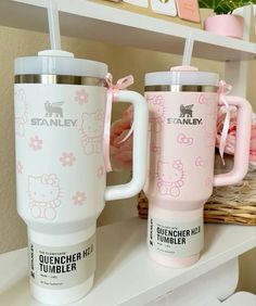 two hello kitty coffee mugs sitting on a shelf