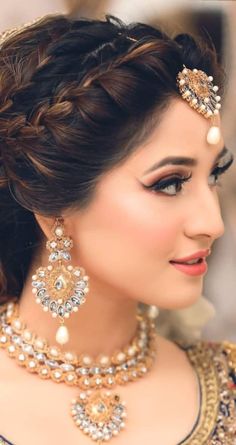 a woman in a bridal outfit with jewelry on her neck and headpieces