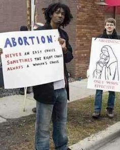 people holding up signs on the sidewalk in front of a brick building with an adorinn written on it