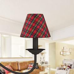 a red and green plaid lamp shade on a black chandelier in a living room