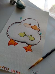 a drawing of a cartoon duck on paper next to a pencil and watercolors