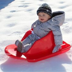 a small child is sitting on a sled in the snow