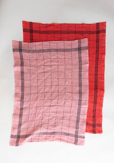 two red and black plaid napkins on a white surface