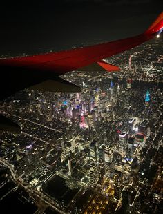 an airplane wing flying over a city at night