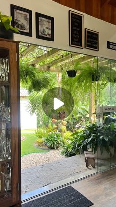 the inside of a house with plants and glass doors