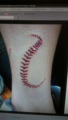 a baseball tattoo on the foot of a person