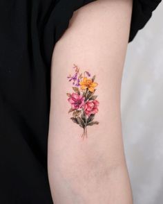 a woman's arm with flowers painted on the back of her arm and shoulder